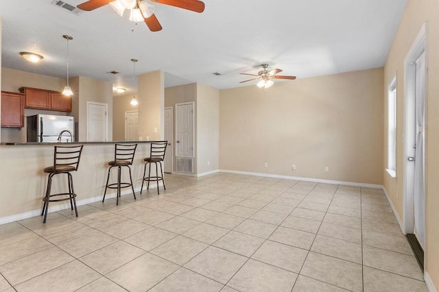 996 Leigh Ann Ln, Fort Walton Beach, FL 32547 - kitchen featuring freestanding refrigerator, a ceiling fan, a breakfast bar area, and light tile patterned floors