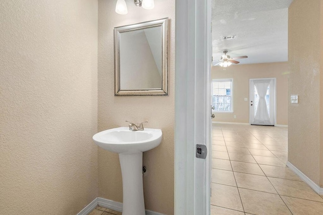 996 Leigh Ann Ln, Fort Walton Beach, FL 32547 - bathroom with ceiling fan, baseboards, tile patterned floors, a textured wall, and a sink