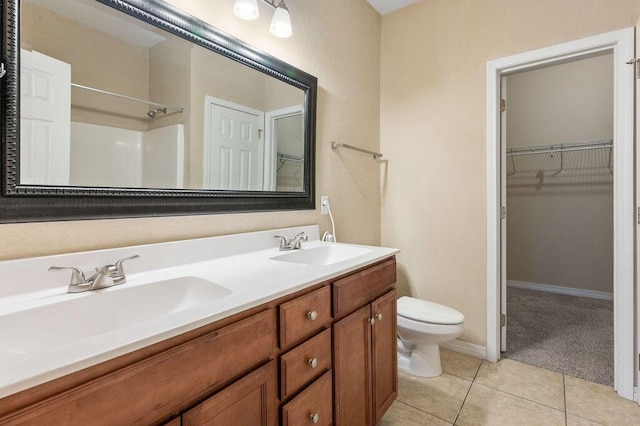 996 Leigh Ann Ln, Fort Walton Beach, FL 32547 - full bath featuring toilet, double vanity, tile patterned floors, a walk in closet, and a shower