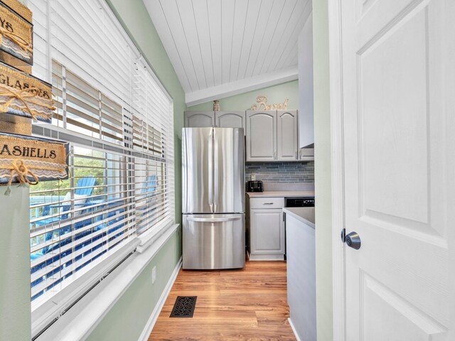 50 Gossamer Ln Unit 10, Inlet Beach, FL 32461 - kitchen featuring freestanding refrigerator, vaulted ceiling, light wood finished floors, light countertops, and backsplash