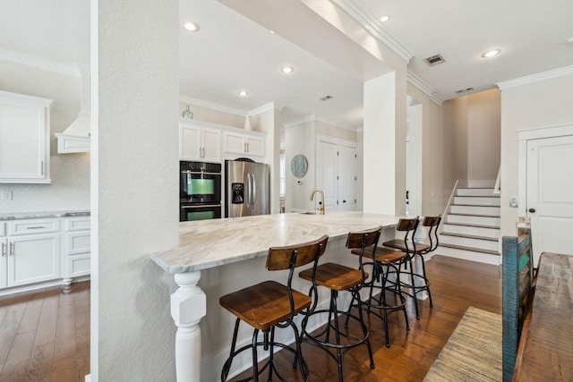 51 Grande Pointe Dr, Inlet Beach, FL 32461 - kitchen with stainless steel refrigerator with ice dispenser, double oven, light stone counters, white cabinetry, and recessed lighting