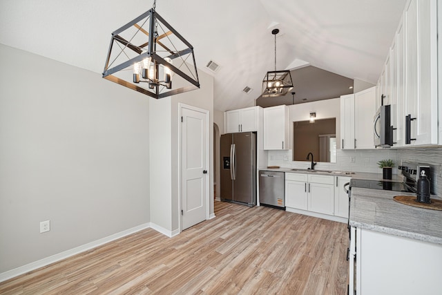 28 6th St, Shalimar, FL 32579 - kitchen with appliances with stainless steel finishes, a chandelier, a sink, backsplash, and high vaulted ceiling