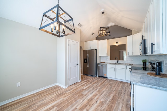 28 6th St, Shalimar, FL 32579 - kitchen featuring stainless steel appliances, a chandelier, a sink, tasteful backsplash, and high vaulted ceiling