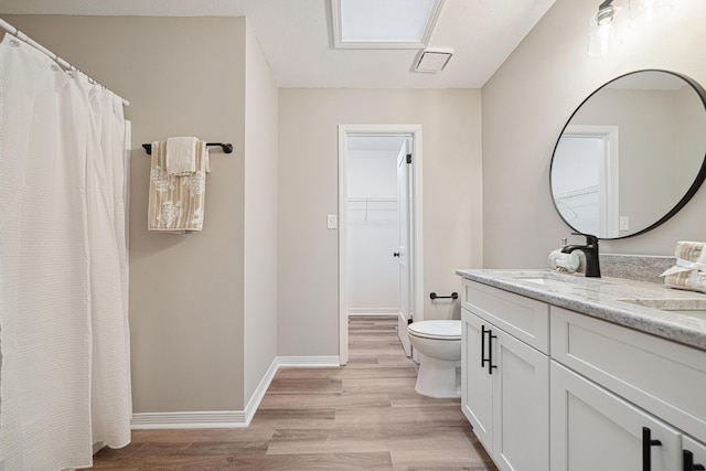 28 6th St, Shalimar, FL 32579 - full bath featuring wood finished floors, toilet, double vanity, a spacious closet, and baseboards