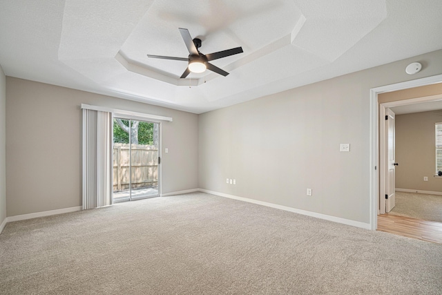 28 6th St, Shalimar, FL 32579 - spare room with light carpet, a ceiling fan, a raised ceiling, baseboards, and a smoke detector