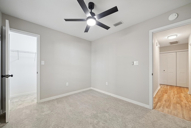 28 6th St, Shalimar, FL 32579 - unfurnished bedroom with carpet, baseboards, a spacious closet, a ceiling fan, and a closet