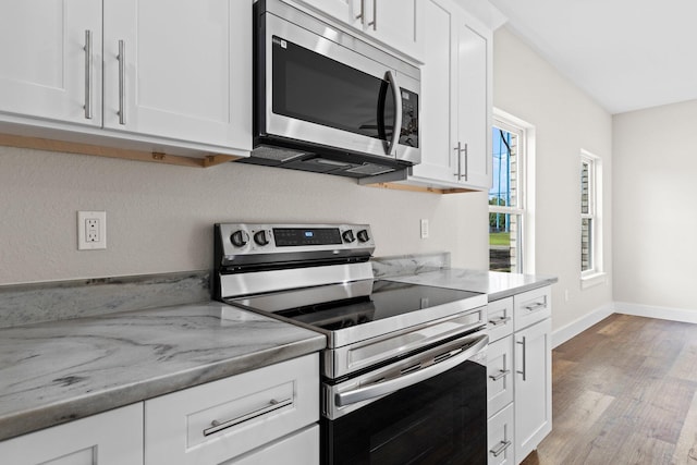 1354 Georgia Ave, Baker, FL 32531 - kitchen with stainless steel appliances, wood finished floors, white cabinetry, and baseboards