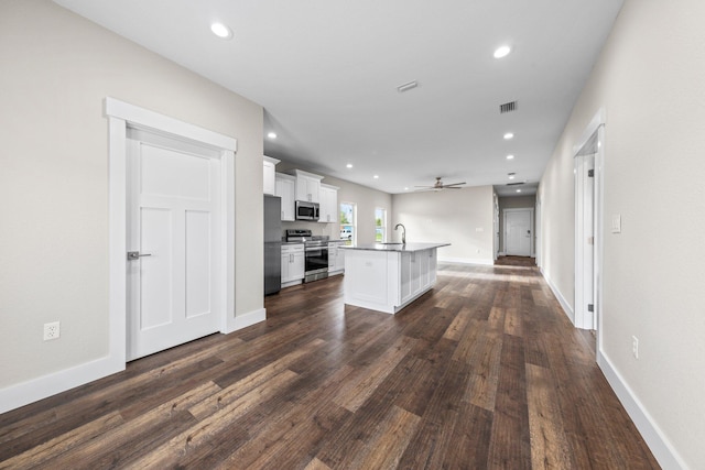 1354 Georgia Ave, Baker, FL 32531 - kitchen with stainless steel appliances, white cabinetry, a kitchen island with sink, ceiling fan, and dark wood finished floors