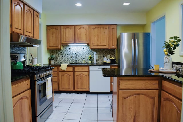 22 10th St, Shalimar, FL 32579 - kitchen with appliances with stainless steel finishes, under cabinet range hood, brown cabinets, tasteful backsplash, and recessed lighting