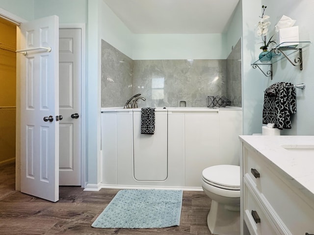 22 10th St, Shalimar, FL 32579 - full bath featuring wood finished floors, vanity, toilet, a walk in closet, and a tub to relax in