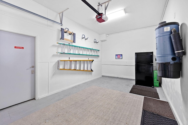 48 Tranquility Ln, Destin, FL 32541 - garage featuring a garage door opener, a central vacuum unit, and freestanding refrigerator