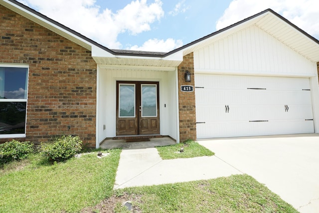 415 Scooter Cv, Crestview, FL 32539 - view of exterior entry featuring french doors, a garage, concrete driveway, and brick siding
