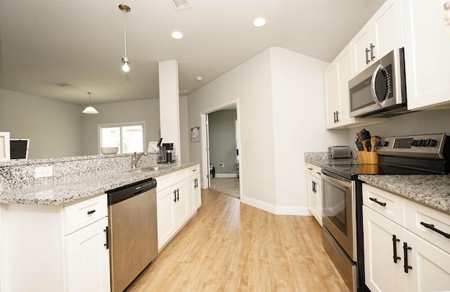 415 Scooter Cv, Crestview, FL 32539 - kitchen with appliances with stainless steel finishes, light wood-style floors, a sink, light stone counters, and white cabinetry