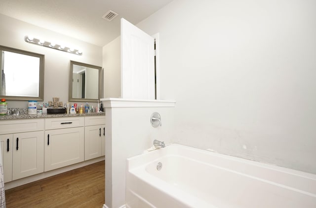 415 Scooter Cv, Crestview, FL 32539 - bathroom featuring double vanity, a bath, and wood finished floors