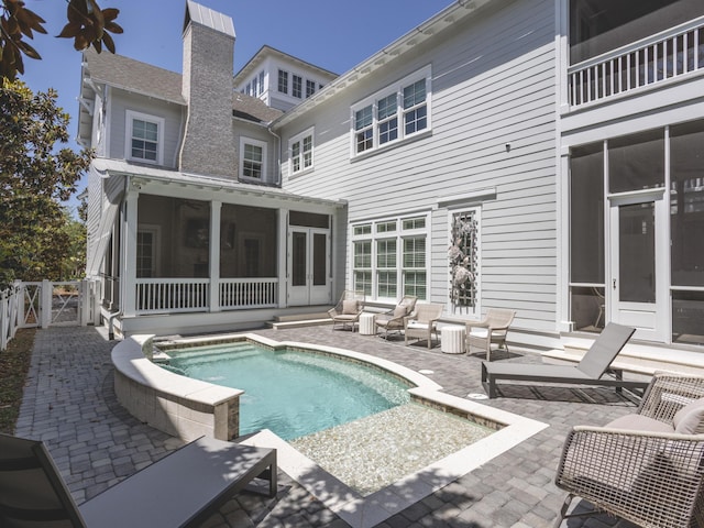 44 Tidepool Ln, Watersound, FL 32461 - swimming pool with a sunroom, a patio area, french doors, and an outdoor hangout area