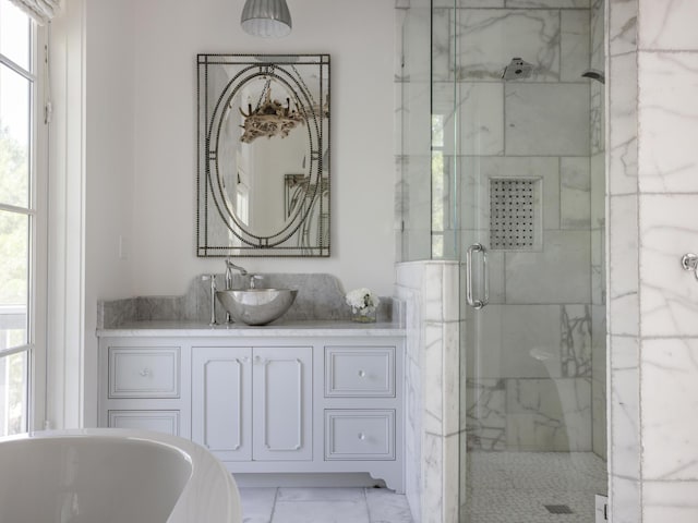 44 Tidepool Ln, Watersound, FL 32461 - bathroom featuring marble finish flooring, a shower stall, a soaking tub, and plenty of natural light