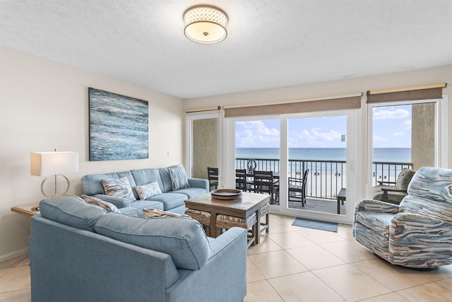 1700 Scenic Highway 98 Unit 207, Destin, FL 32541 - living room featuring a water view, light tile patterned flooring, and a textured ceiling