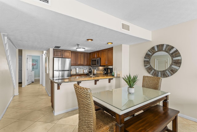 1700 Scenic Highway 98 Unit 207, Destin, FL 32541 - dining area featuring light tile patterned flooring, baseboards, and a textured ceiling