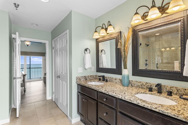 1700 Scenic Highway 98 Unit 207, Destin, FL 32541 - bathroom with a stall shower, baseboards, double vanity, and tile patterned flooring