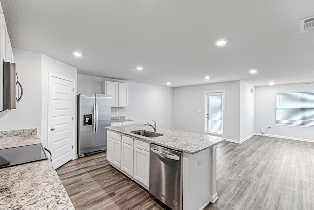 205 Laurel Hill St, Crestview, FL 32539 - kitchen featuring stainless steel appliances, a sink, wood finished floors, a kitchen island with sink, and white cabinets