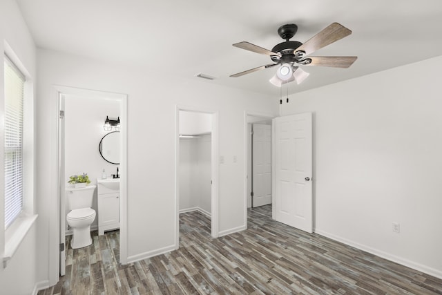 306 Forrest Pkwy, Crestview, FL 32539 - bedroom with wood finished floors, a closet, a walk in closet, connected bathroom, and baseboards