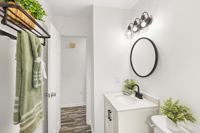 306 Forrest Pkwy, Crestview, FL 32539 - bathroom with vanity, wood finished floors, toilet, and baseboards