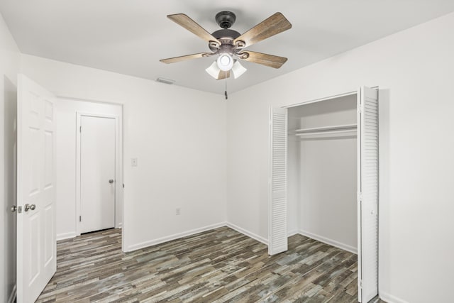 306 Forrest Pkwy, Crestview, FL 32539 - unfurnished bedroom featuring wood finished floors, a closet, baseboards, and ceiling fan