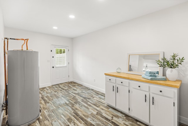 306 Forrest Pkwy, Crestview, FL 32539 - kitchen featuring water heater, light wood-style floors, baseboards, white cabinetry, and recessed lighting