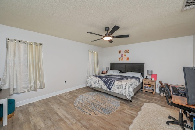 6229 Flash Ln, Crestview, FL 32536 - bedroom with wood finished floors, baseboards, ceiling fan, and a textured ceiling