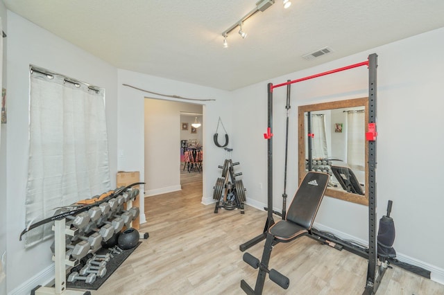 6229 Flash Ln, Crestview, FL 32536 - exercise room with wood finished floors, baseboards, and a textured ceiling