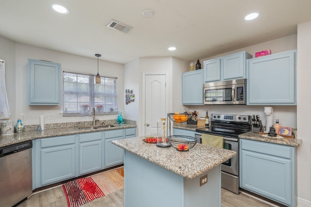 6229 Flash Ln, Crestview, FL 32536 - kitchen with stainless steel appliances, a sink, blue cabinetry, light wood-style flooring, and recessed lighting