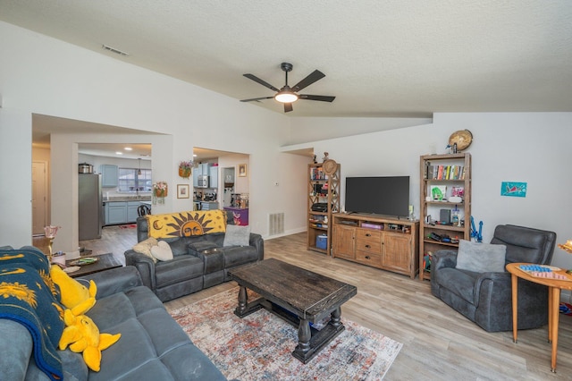 6229 Flash Ln, Crestview, FL 32536 - living area featuring a ceiling fan, light wood-type flooring, vaulted ceiling, and a textured ceiling
