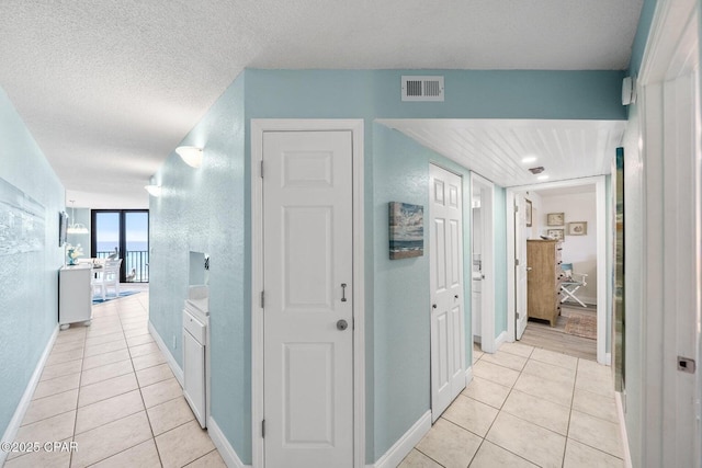 17155 Front Beach Rd Unit W405, Panama City Beach, FL 32413 - hall featuring light tile patterned flooring, baseboards, and a textured ceiling