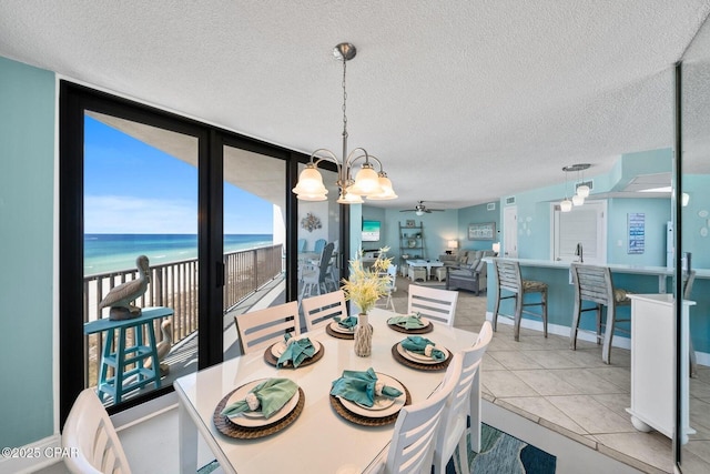 17155 Front Beach Rd Unit W405, Panama City Beach, FL 32413 - tiled dining room with a ceiling fan, a textured ceiling, and a water view