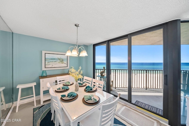 17155 Front Beach Rd Unit W405, Panama City Beach, FL 32413 - dining area with a water view, a wall of windows, a chandelier, a textured ceiling, and baseboards