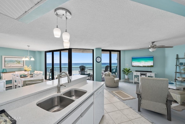 17155 Front Beach Rd Unit W405, Panama City Beach, FL 32413 - kitchen with a sink, white cabinets, hanging light fixtures, white dishwasher, and light countertops