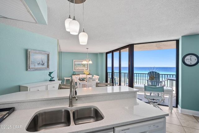 17155 Front Beach Rd Unit W405, Panama City Beach, FL 32413 - kitchen with white dishwasher, a sink, a water view, pendant lighting, and light tile patterned floors