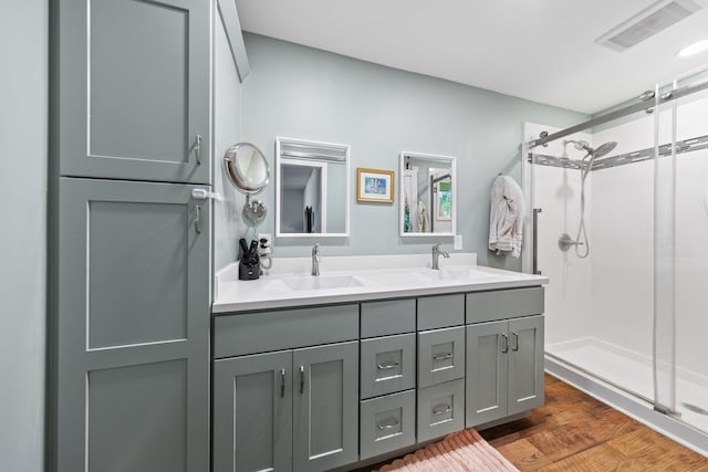 207 Oakwood Cir, Niceville, FL 32578 - bathroom featuring a stall shower, double vanity, and wood finished floors