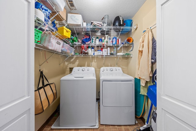 207 Oakwood Cir, Niceville, FL 32578 - laundry room with washing machine and dryer and a textured ceiling