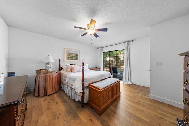 207 Oakwood Cir, Niceville, FL 32578 - bedroom featuring wood finished floors, a textured ceiling, a ceiling fan, and baseboards