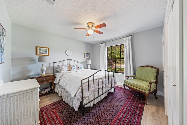 207 Oakwood Cir, Niceville, FL 32578 - bedroom with wood finished floors, a textured ceiling, and ceiling fan