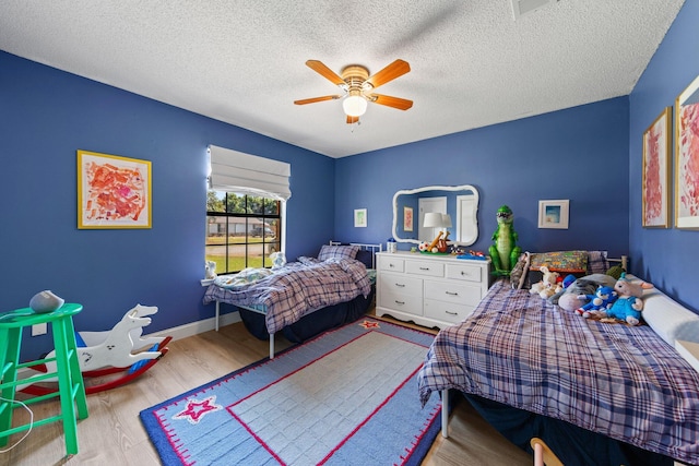 207 Oakwood Cir, Niceville, FL 32578 - bedroom featuring wood finished floors, a ceiling fan, and a textured ceiling