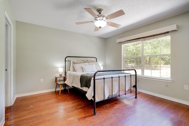 4236 Edge Perry Rd, Crestview, FL 32539 - bedroom featuring wood finished floors, a textured ceiling, baseboards, and ceiling fan