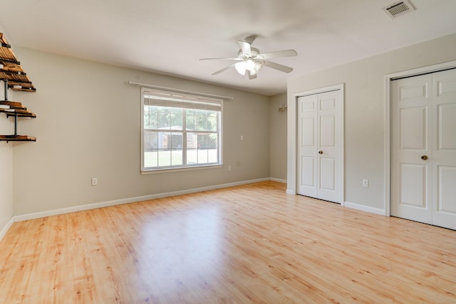 4236 Edge Perry Rd, Crestview, FL 32539 - unfurnished bedroom with two closets, light wood-style floors, baseboards, and ceiling fan