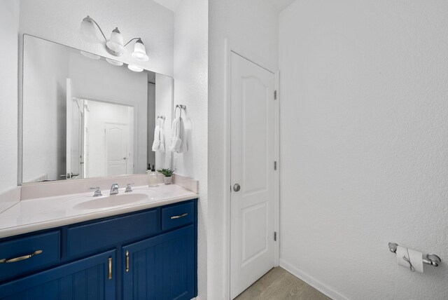 142 Southfields Rd, Panama City Beach, FL 32413 - bathroom with vanity, wood finished floors, baseboards, and a closet
