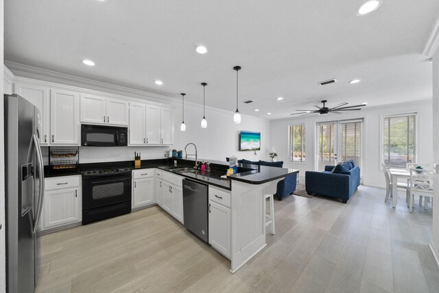 142 Southfields Rd, Panama City Beach, FL 32413 - kitchen with black appliances, a sink, open floor plan, a peninsula, and dark countertops