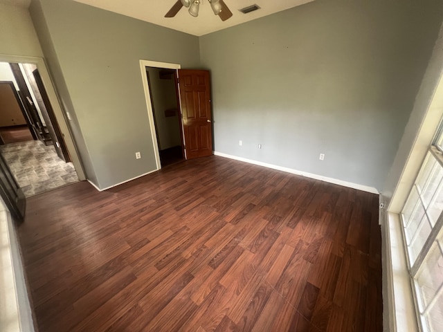 4932 Joiner Cir, Milton, FL 32583 - unfurnished bedroom featuring dark wood-type flooring, baseboards, ceiling fan, and a walk in closet