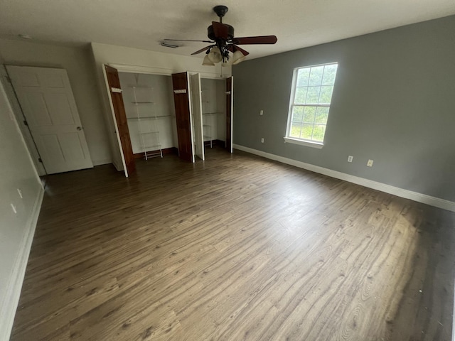 4932 Joiner Cir, Milton, FL 32583 - unfurnished bedroom featuring baseboards, dark wood finished floors, multiple closets, and ceiling fan