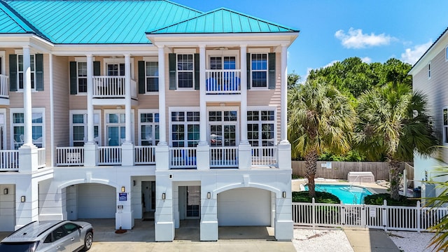 512 Dement Cir Apt F, Panama City Beach, FL 32407 - view of front of house featuring a standing seam roof, a garage, a community pool, and metal roof