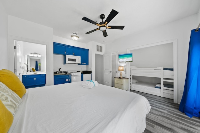 512 Dement Cir Apt F, Panama City Beach, FL 32407 - bedroom featuring a sink, wood finished floors, connected bathroom, and a ceiling fan